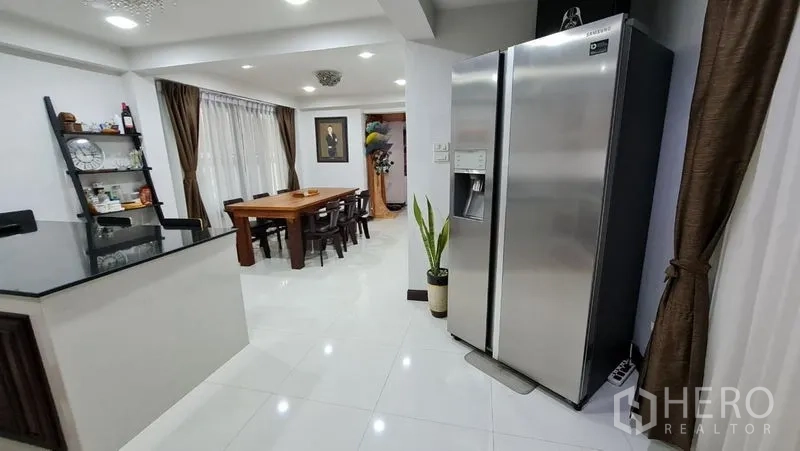 Detached House for rent in Saphan Sung, Bangkok - Bright kitchen and dining area with island counter and double-door refrigerator.