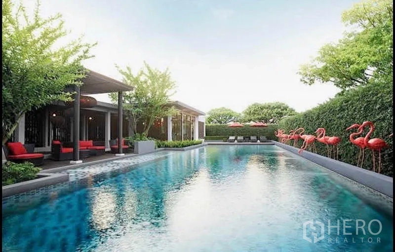 Townhouse for sale in Khlong Toei, Bangkok - Communal resort-style swimming pool with cabanas, seating areas and landscaped greenery.