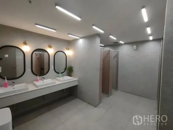 Office Space for rent in Bang Rak, Bangkok - Contemporary restroom with multiple sinks, framed mirrors and private toilet stalls in neutral tones.