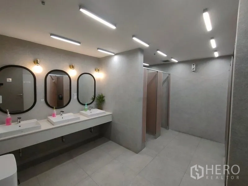 Office Space for rent in Bang Rak, Bangkok - Contemporary restroom with multiple sinks, framed mirrors and private toilet stalls in neutral tones.