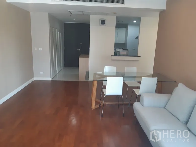 Condominium for rent in Khlong Toei, Bangkok - Open-plan dining and lounge with wood floors and access to the kitchen and entry hall.