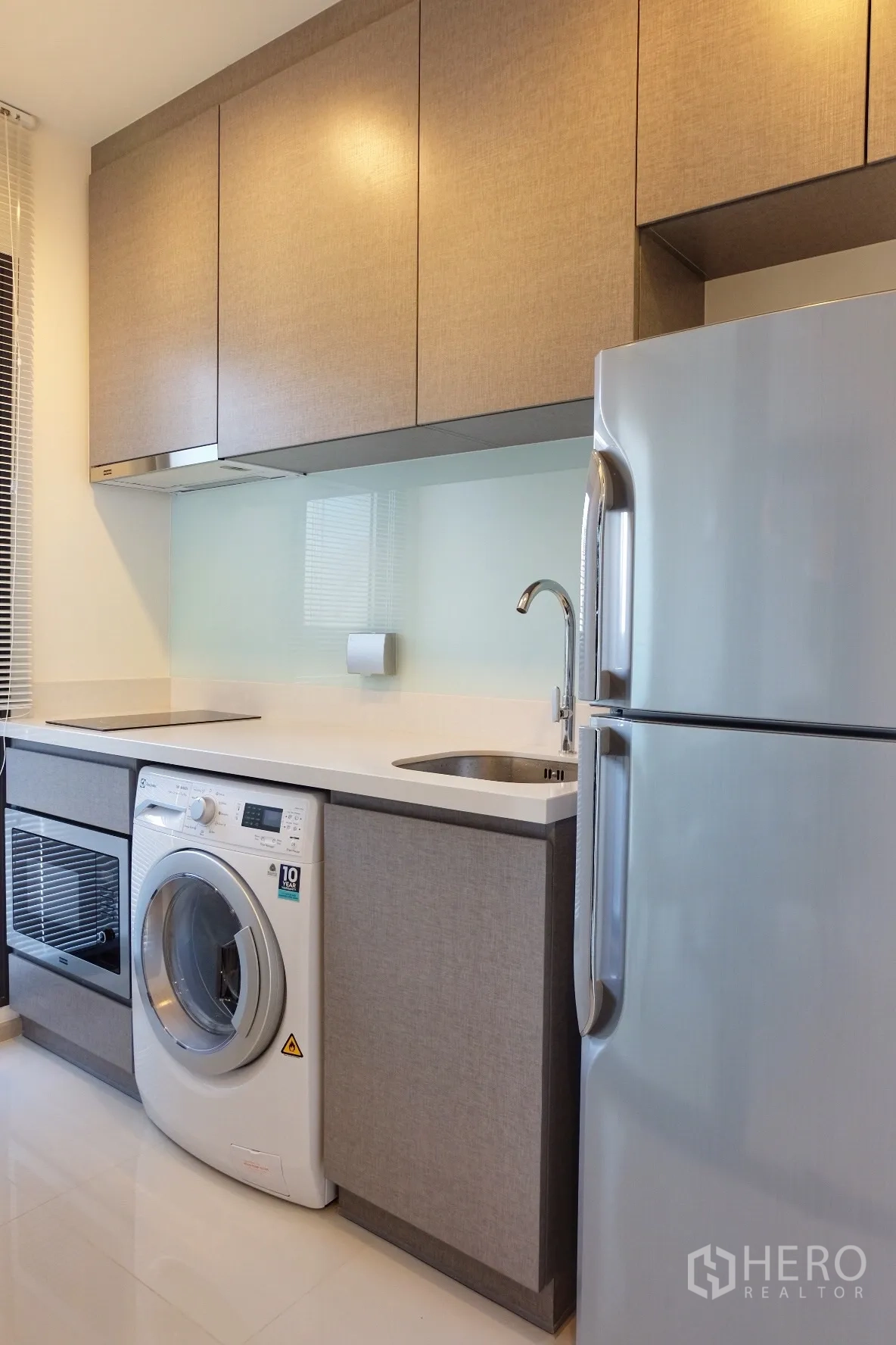 Condominium for rent in Khlong Toei, Bangkok - Compact kitchen with built-in cabinets, glass backsplash, hob, oven, washer and fridge.