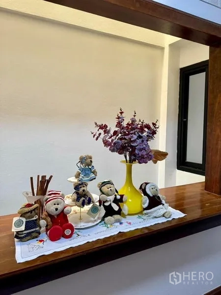 Home Office for rent in Khlong Toei, Bangkok - Built-in display ledge with vases and ornaments along white wall.