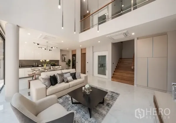 Detached House for rent or sale in Yan Nawa, Bangkok - Double-height living room with modern sofa set, open kitchen and dining area.