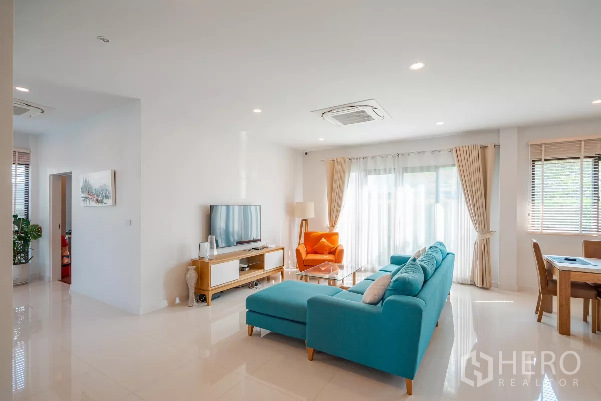 Detached House for sale in Saphan Sung, Bangkok - Bright family room view with TV, sofa and garden-facing sliding doors.