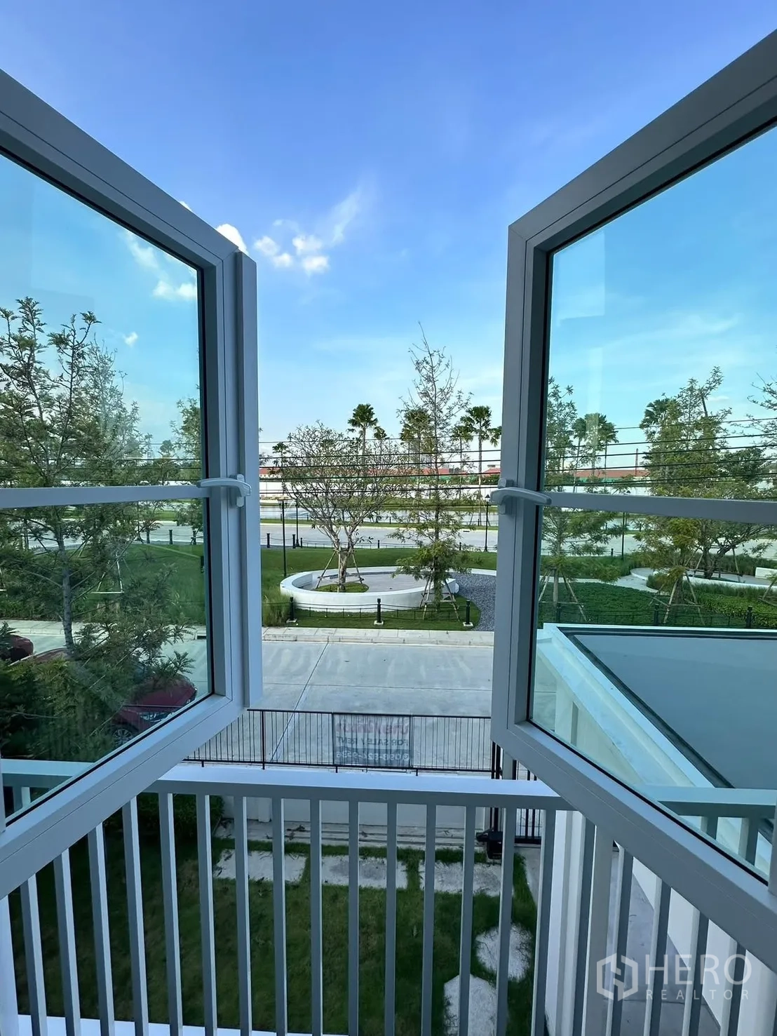 独栋房屋 for rent in Bang Phli, Samut Prakan - 打开的窗户俯瞰园景与小区道路。