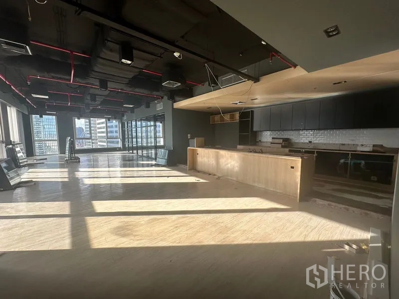 办公空间 出租在Bang Rak, Bangkok - 阳光充沛的开放式办公区，吧台式茶水间与曼谷天际线同框。