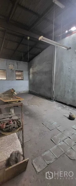Shophouse for rent in Khlong Toei, Bangkok - Spacious workshop-style room with high roof and hanging lights.