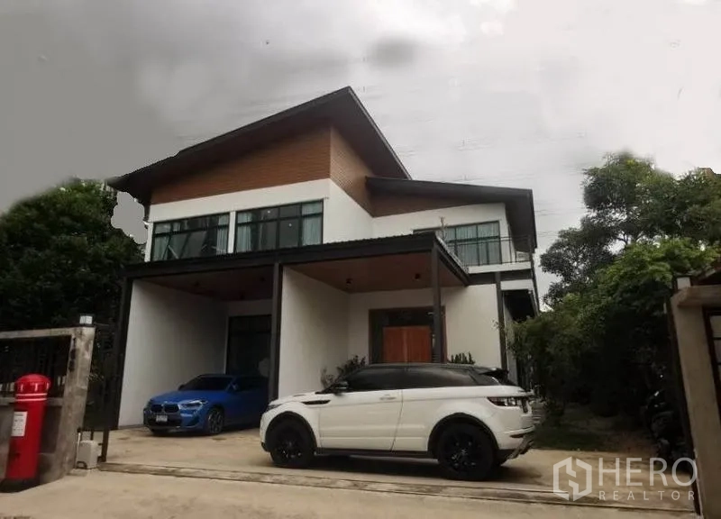 独立式住宅 出售在Pak Kret, Nonthaburi - 独栋别墅正立面，斜屋顶、阳台与双车位。