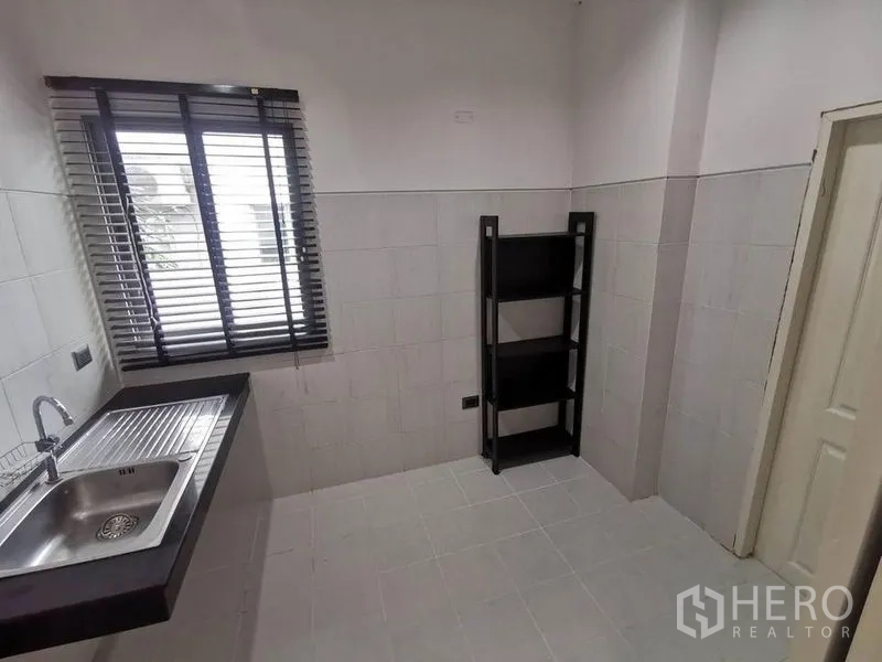 บ้าน ให้เช่าในPrawet, Bangkok - ครัวปิดเรียบง่าย ซิงก์สแตนเลส ผนังกระเบื้อง และมู่ลี่หน้าต่าง