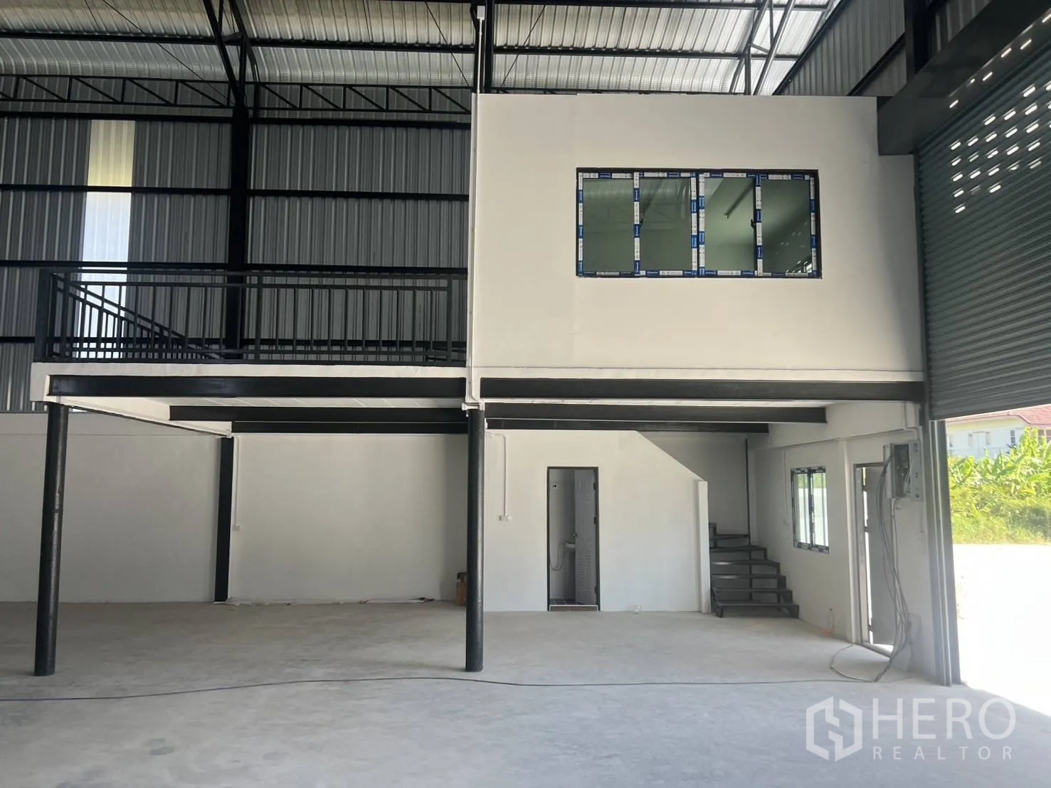 仓库 for rent in Bang Phli, Samut Prakan - 夹层办公室近景，带窗户与楼梯，旁有大型卷闸门入口。