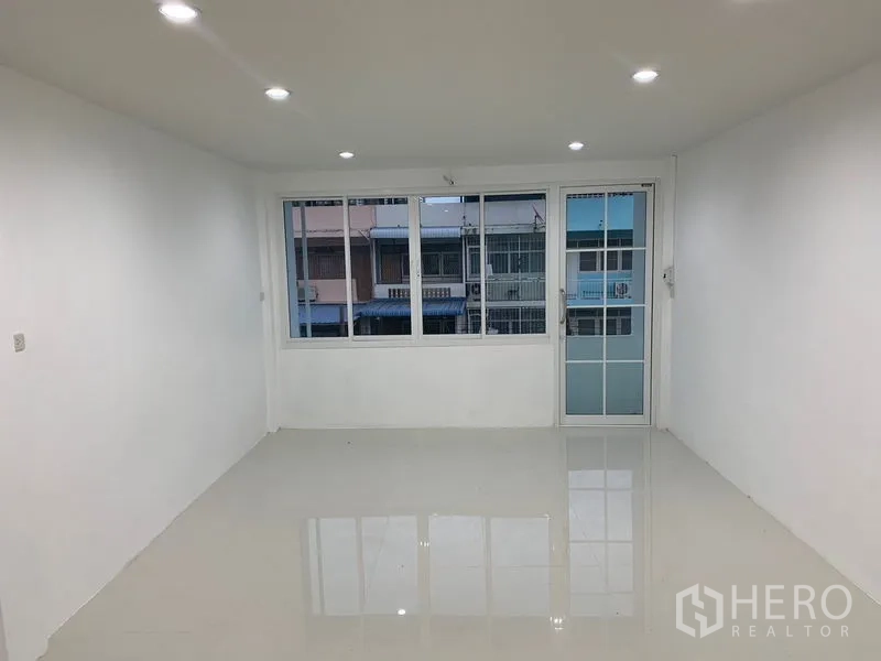 Townhouse for sale in Yan Nawa, Bangkok - Spacious bedroom with wide windows and sliding door to a balcony.