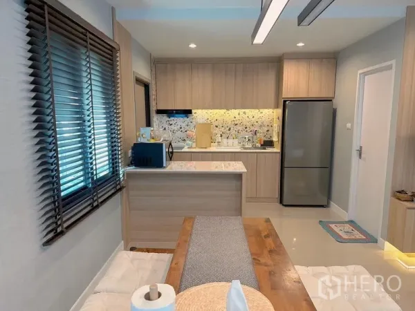 บ้าน ขาย - ครัวบิวท์อินโทนไม้ เคาน์เตอร์บาร์ และผนังลายเทอราซโซติดกับโต๊ะอาหาร