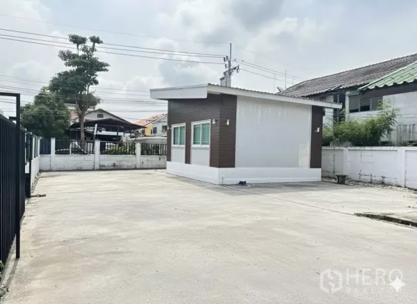 Home Office for rent in Bang Phli, Samut Prakan - Open paved yard with a compact office pavilion and perimeter wall, ideal for multi-car parking.