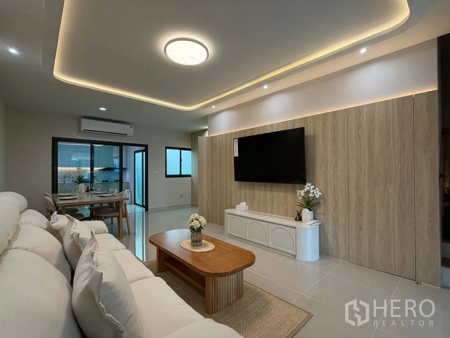 Townhouse for rent in Bang Phli, Samut Prakan - Living room featuring a TV wall, recessed ceiling lights, and air conditioning.