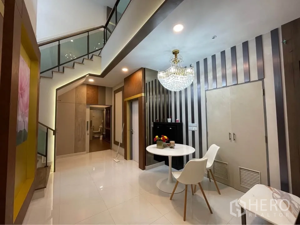 独栋房屋 for rent or sale in Bang Phli, Samut Prakan - 楼梯平台区带条纹装饰墙与水晶吊灯。
