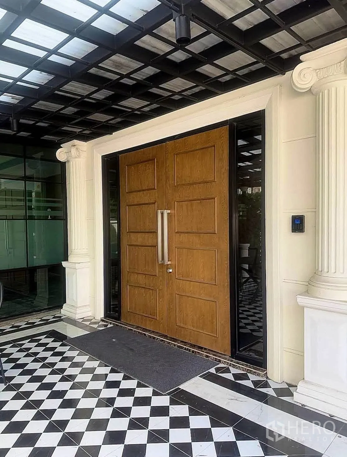 Home Office for rent in Lat Phrao, Bangkok - Grand timber double doors under a covered portico with black and white tiled entrance.