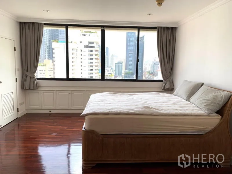 Condominium for sale in Khlong Toei, Bangkok - Guest bedroom with large window, city view and hardwood flooring.