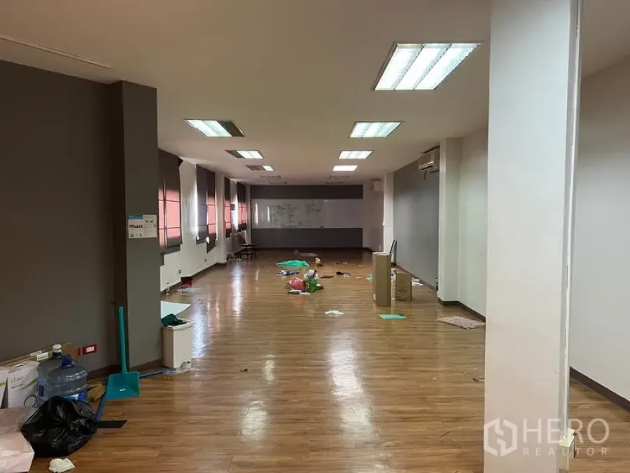 办公空间 出租在Khlong Toei, Bangkok - 开放式办公室，木纹地板，吊顶日光灯，长窗配百叶，尽头设有白板。