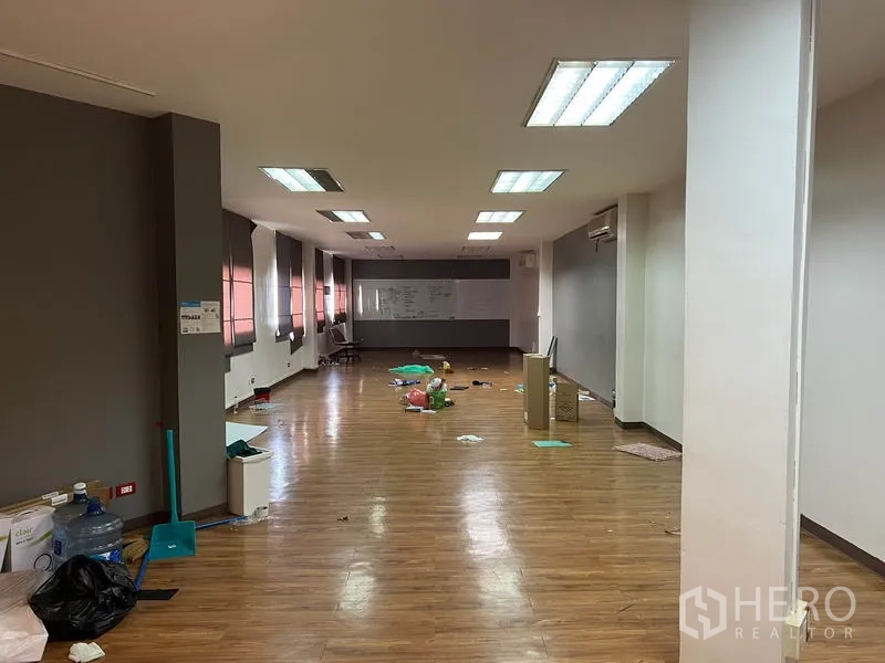 办公空间 出租在Khlong Toei, Bangkok - 开放式办公室，木纹地板，吊顶日光灯，长窗配百叶，尽头设有白板。