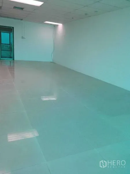 办公空间 出租在Huai Khwang, Bangkok - 长条形开放式办公室，白墙、地砖、吊顶与后侧出入口。