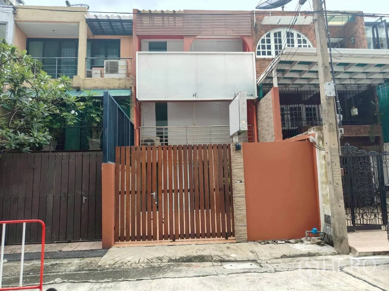 家庭办公室 for rent in Watthana, Bangkok - 三层联排外立面，木栅栏大门与阳台。