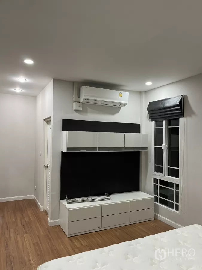 Detached House for rent in Bang Kapi, Bangkok - Master bedroom with TV wall unit, storage cabinets and air conditioning.
