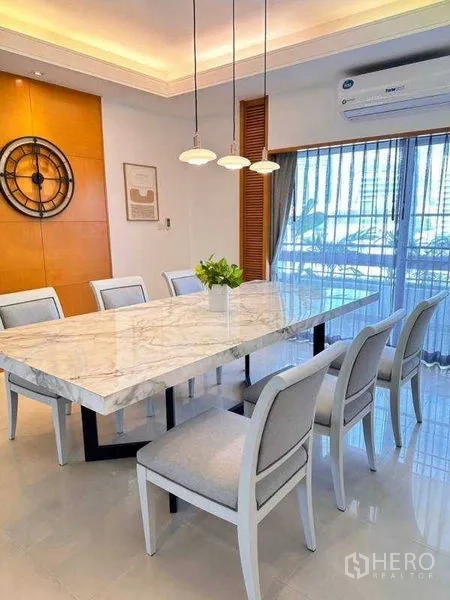 Apartment for rent - Alternate view of the dining area with marble table and wall clock feature.