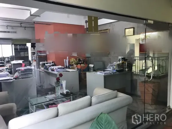 办公空间 出租在Watthana, Bangkok - 玻璃隔断后的开放式办公室，多张办公桌与沙发会客区。