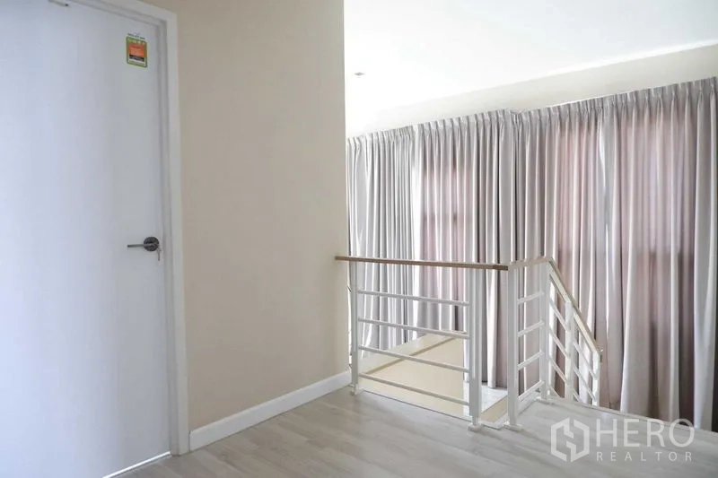 独立式住宅 出售在Lat Krabang, Bangkok - 二层过道另一视角，窗帘与白门明亮整洁