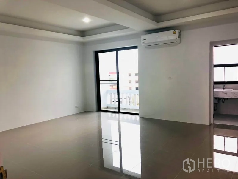 带办公室的家 出租在Khlong Toei, Bangkok - 明亮开放空间，亮面瓷砖地、吊顶，推拉门通阳台，墙挂空调与浴室入口。