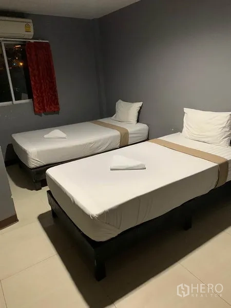 Retail Space for rent in Khlong Toei, Bangkok - Twin-bed bedroom with gray walls, window and air conditioning.