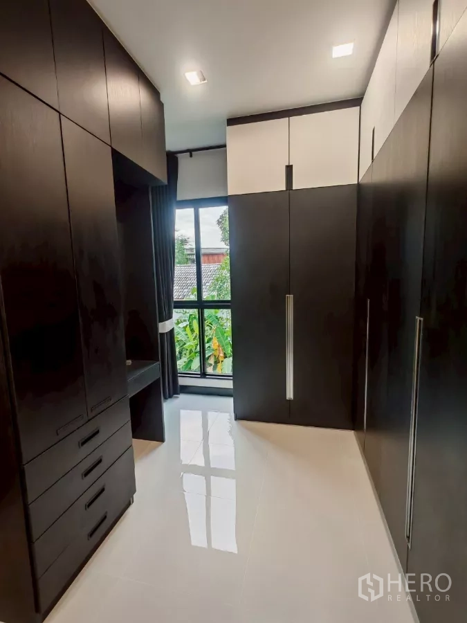 Detached House for rent in Wang Thonglang, Bangkok - Walk-in closet with full-height cabinetry and window views of greenery.