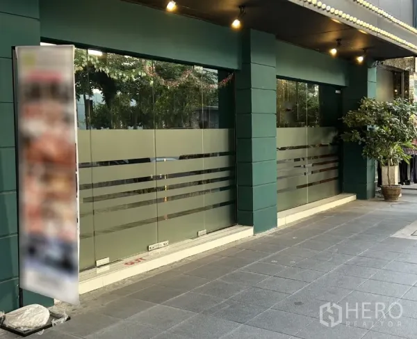 พื้นที่ขายปลีก ให้เช่าในKhlong Toei, Bangkok - หน้าร้านชั้นล่างกระจกบานใหญ่ เสาโทนเขียว และทางเดินมีหลังคา ในย่านสุขุมวิท คลองเตย
