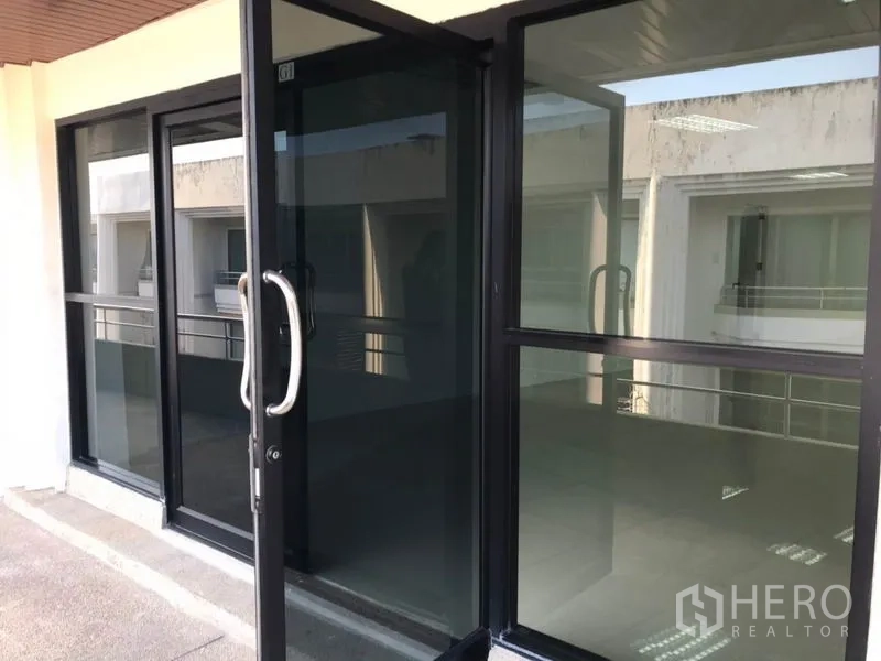 办公空间 出租在Watthana, Bangkok - 黑色铝框玻璃推拉门入口，外接走廊阳台。