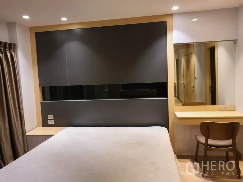 Condominium for rent in Watthana, Bangkok - Master bedroom featuring statement headboard, bed, vanity desk, wall mirror and recessed lighting.