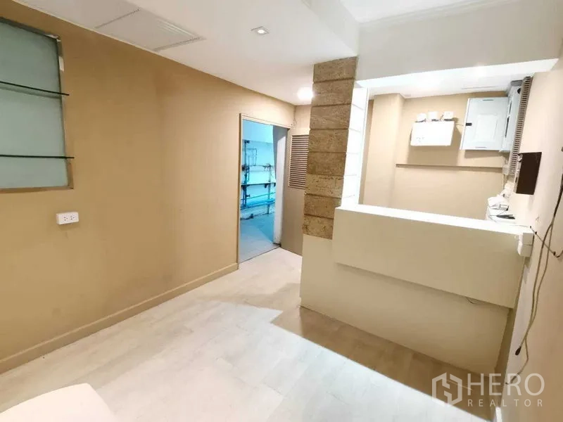 Retail Space for rent in Pathum Wan, Bangkok - Wide paved driveway with landscaping and covered parking beside city buildings.