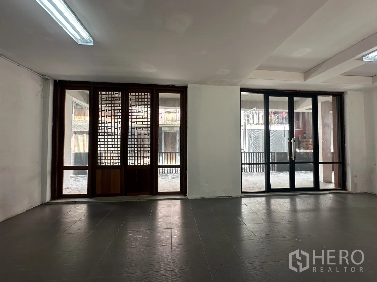 带办公室的家 出租在Pathum Wan, Bangkok - 明亮办公区，双玻璃推拉门与木格栅窗，面向中庭。