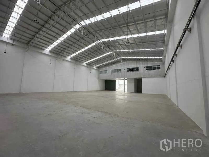 Factory for rent in Khlong Luang, Pathum Thani - Bright warehouse bay with extensive clear height and lighting suitable for racking and operations.