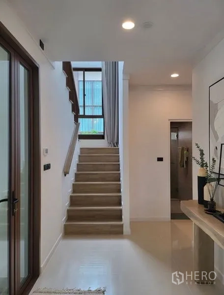 独立式住宅 出租在Bang Kapi, Bangkok - 入口走廊与楼梯，落地窗带来自然采光。