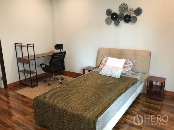 Townhouse for rent or sale in Phra Khanong, Bangkok - Bedroom with wooden flooring, single bed, study desk and wall art.