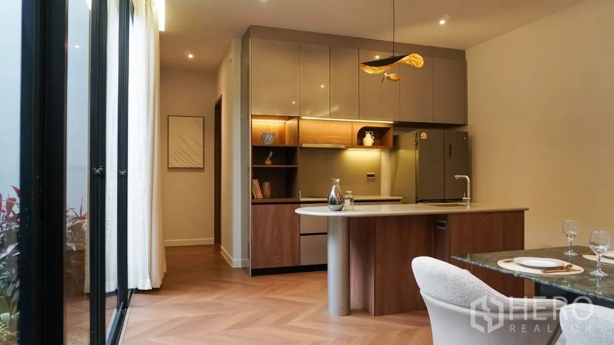 Detached House for rent or sale in Bang Kapi, Bangkok - Contemporary Western kitchen with island, wood cabinetry and warm under-cabinet lighting.