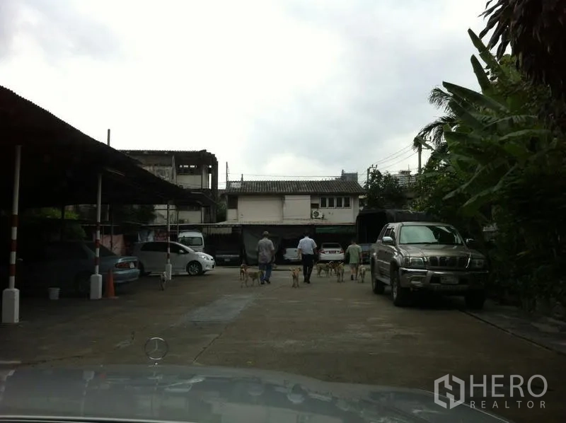 Factory for rent in Khlong San, Bangkok - Parking area with covered bays, pickup truck and greenery at the industrial compound.