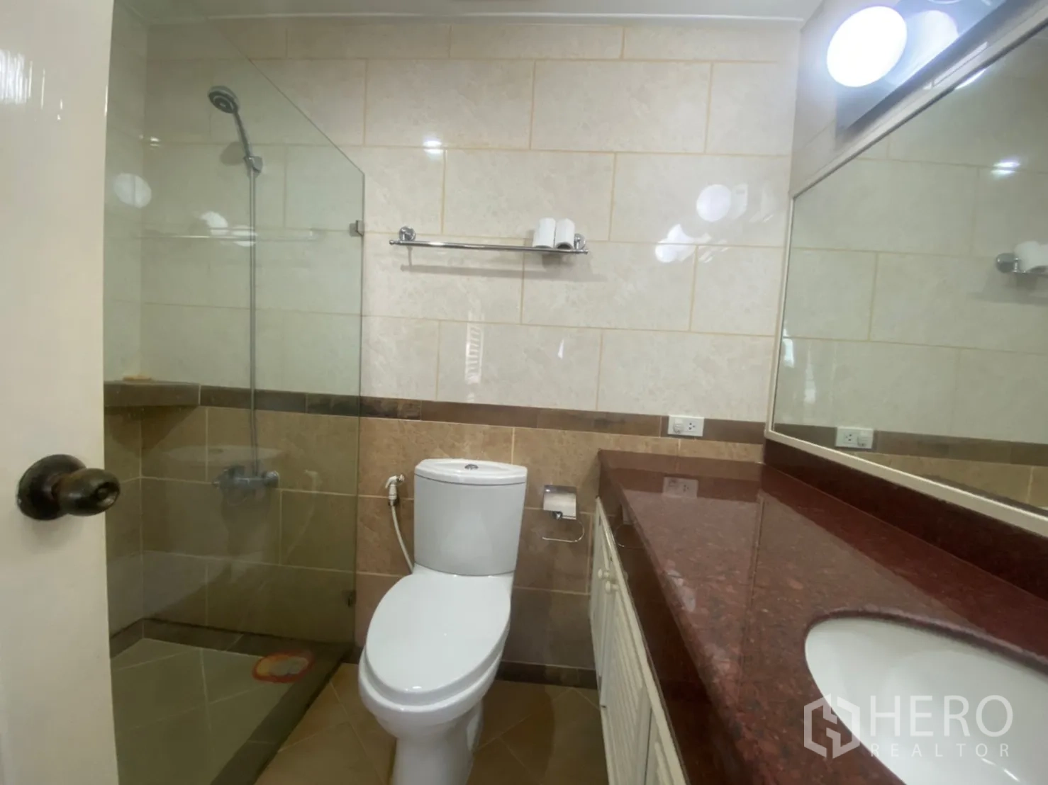 Condominium for rent or sale in Watthana, Bangkok - Bathroom with glass shower, large vanity and stone countertop.