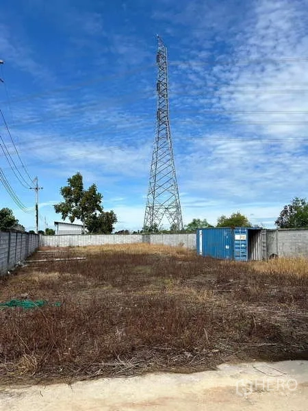 货栈 出售在Lat Lum Kaeo, Pathum Thani - 围合院内的大型空地，可见高压电塔与集装箱。