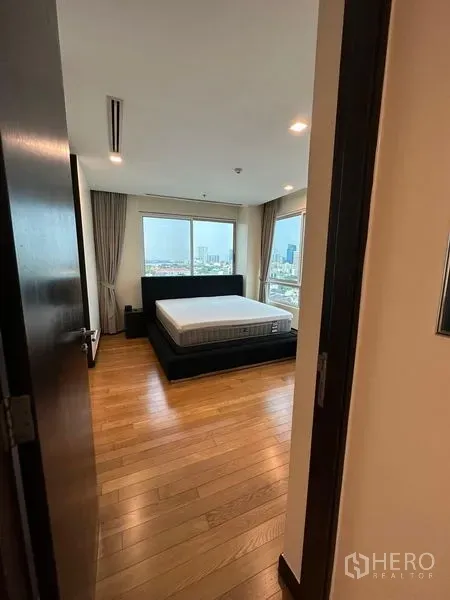 公寓 出租在Yan Nawa, Bangkok - 卧室设大窗与木地板，欣赏城市天际线景观。