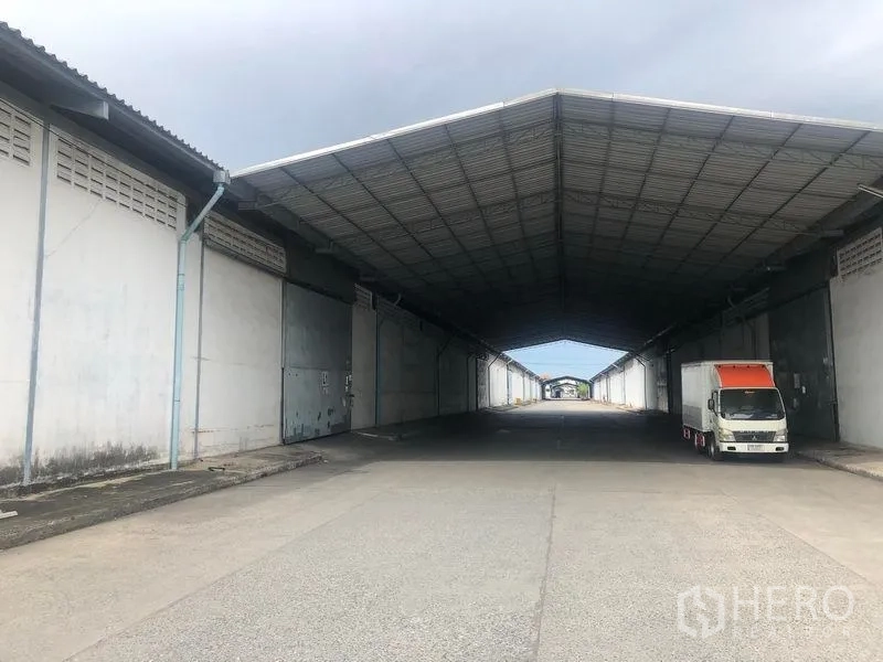 Warehouse for rent in Bang Pa-in, Phra Nakhon Si Ayutthaya - Covered loading bay between warehouses with truck access under a deep canopy.
