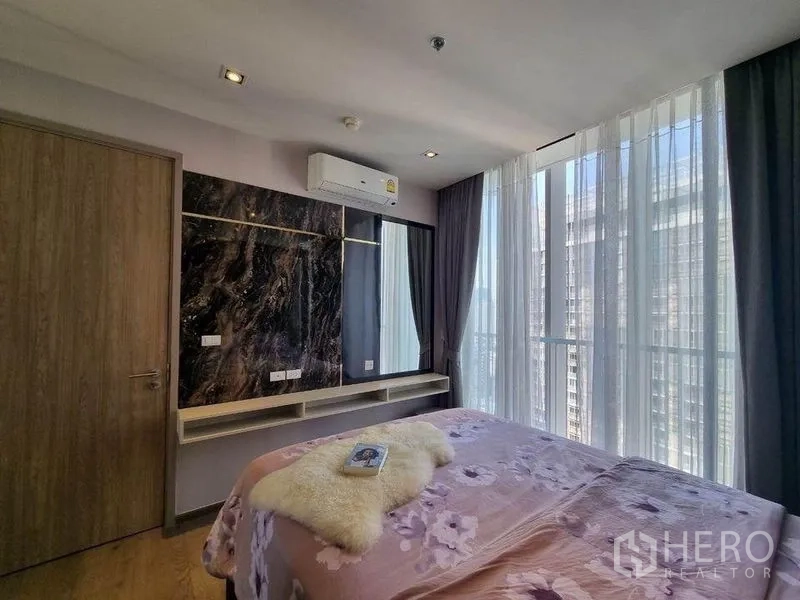 Condominium for sale - Bright bedroom with corner glass, vanity shelf and city views near BTS Phrom Phong.