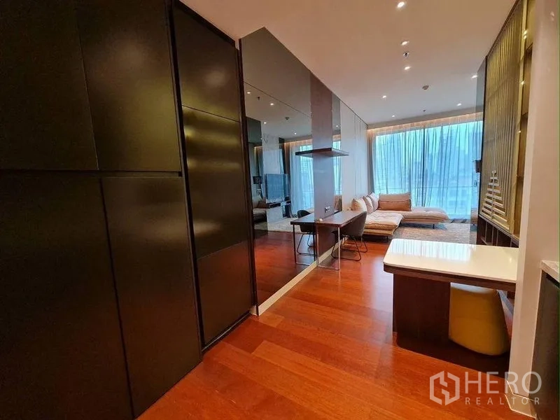 公寓 出租或出售在Watthana, Bangkok - 通往客厅的过道，深色柜体、镜面与工作桌一体化设计。