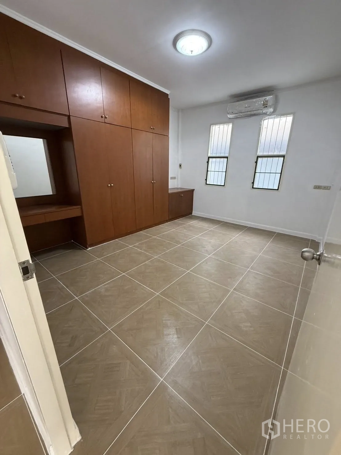 独栋房屋 for rent in Khlong Toei, Bangkok - 卧室设木质嵌入式衣柜，瓷砖地面、空调与高窗。